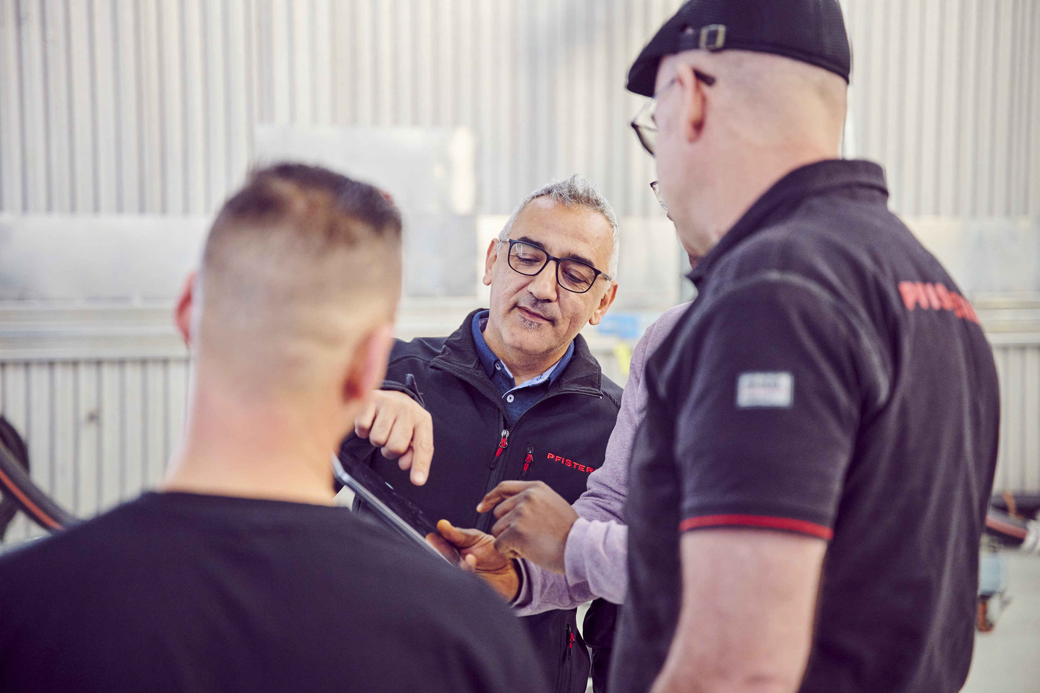 Vier Männer, die ein Tablet bedienen